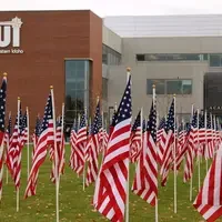 Multiple american flags with CWI buildings in background