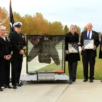 Veterans with Jacket in shadow box at Veterans Day event tighter shot
