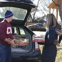 Scott Straub and Courtney Santillan unloading a trunk-full of school supplies to donate to City Light