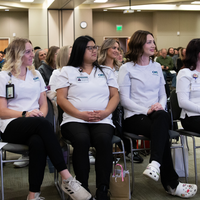 Three students sitting watching a speaker