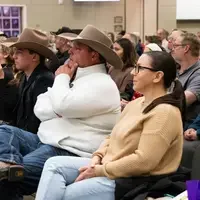 Audience members watching a speaker 
