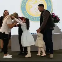 Small children placing a pin over a womans head