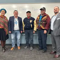 Five people posing for a picture at the event