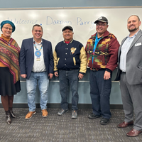 Five people posing for a picture at the event