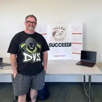 A man stands in front of a poster displaying information for a business idea.