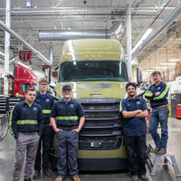 Students pose in front of a newly donated 2018 Daimler Cascadia Freightliner.