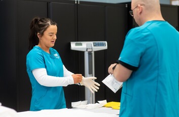 Medical Assistant student putting on gloves