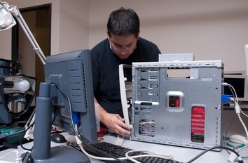 Student working on the insides of a computer tower