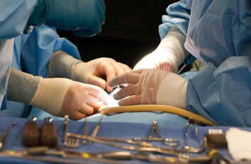 Close up of gloved hands and tools during a surgery