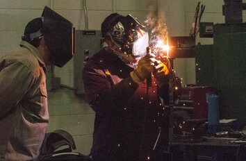 Two welders working on project in lab