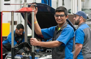 CWI students in an auto technology lab and one is looking at the camera