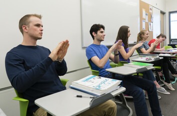 Students practicing signing in a classroom