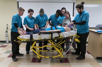 CWI students surrounding a gurney