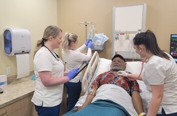 Three students monitoring patients vitals in healthcare lab