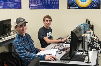 Two CWI students sitting  at computers