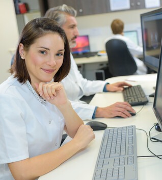 Medical Administrative Support specialist working at computer in office