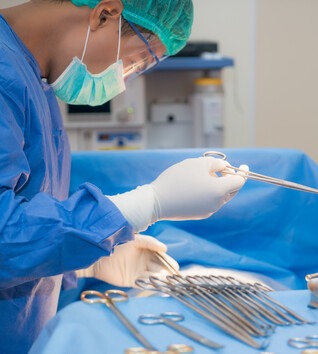 Surgical Technologists working with tools in an operating room