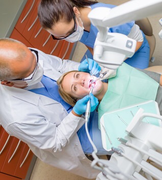 Looking down on patient with dentist and dental assistant