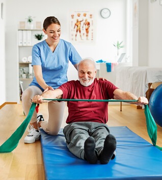 Physical Therapist Assistant helping a patient do exercises in clinic