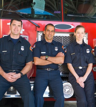Group of fire fighters sitting on front of fire truck