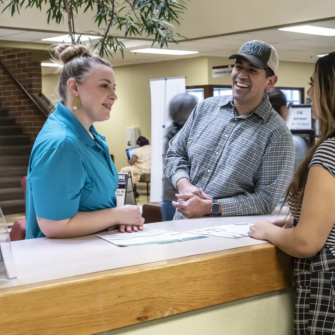 Three people chatting at a front desk