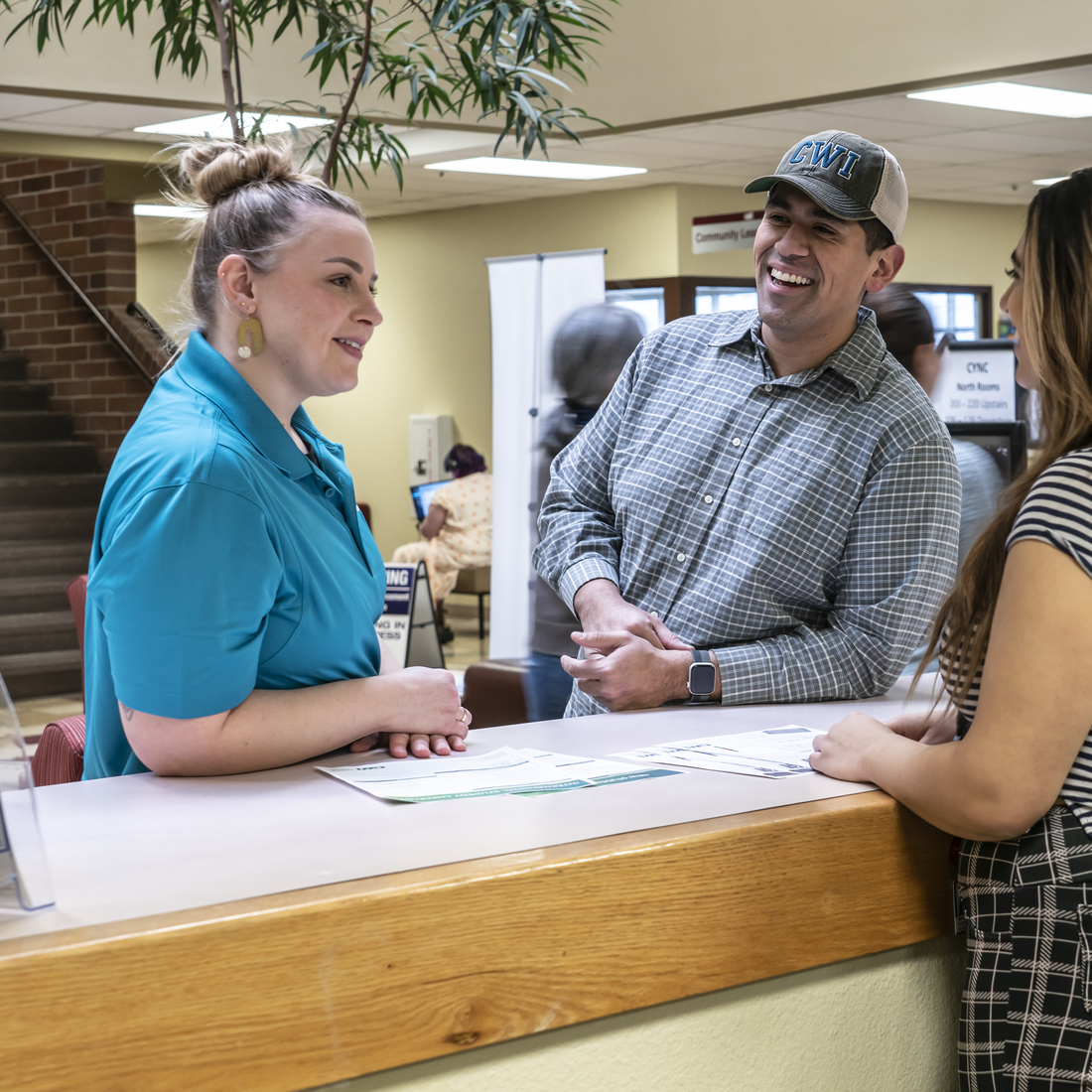 Three people chatting at a front desk