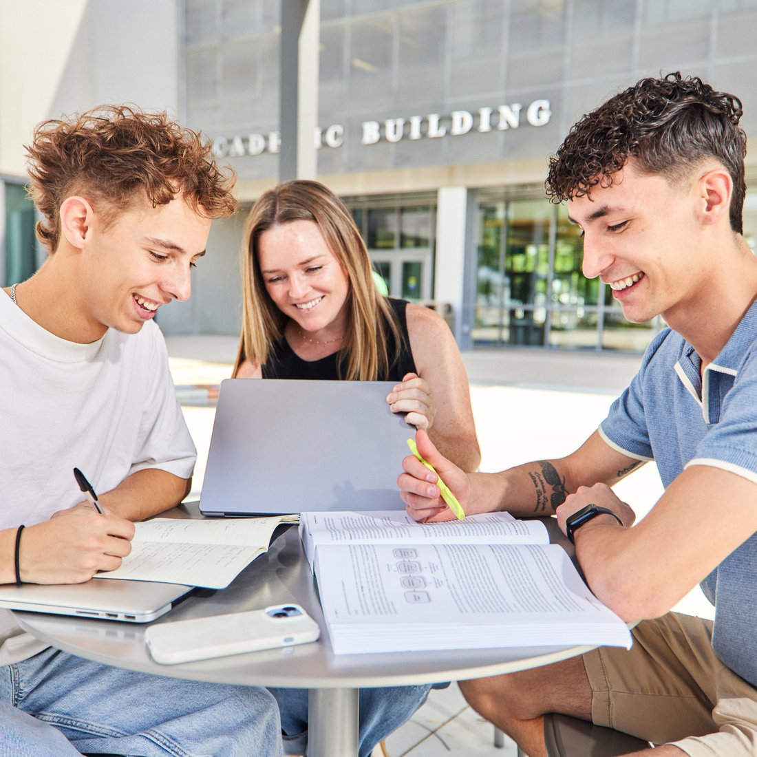 Three students at a table, studying
