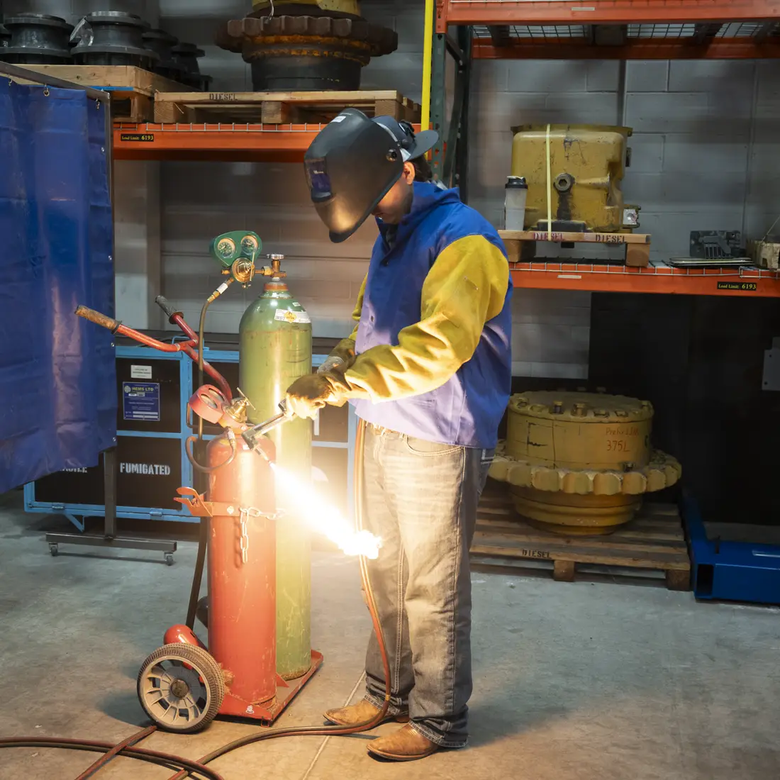 Person welding in a lab with a helmet on