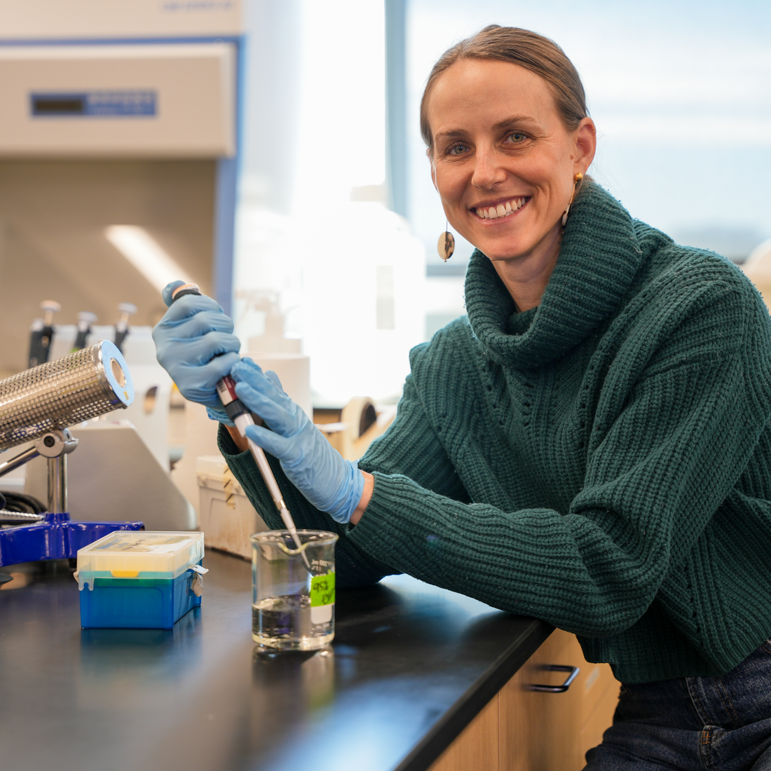 Elise Connor with a pipette at a lab counter