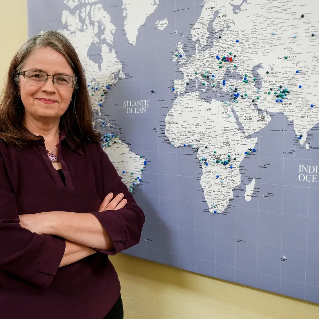 Holly Bazarski stands in front of world map