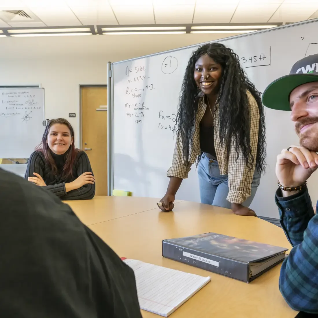 Tutor working with students in front of a whiteboard