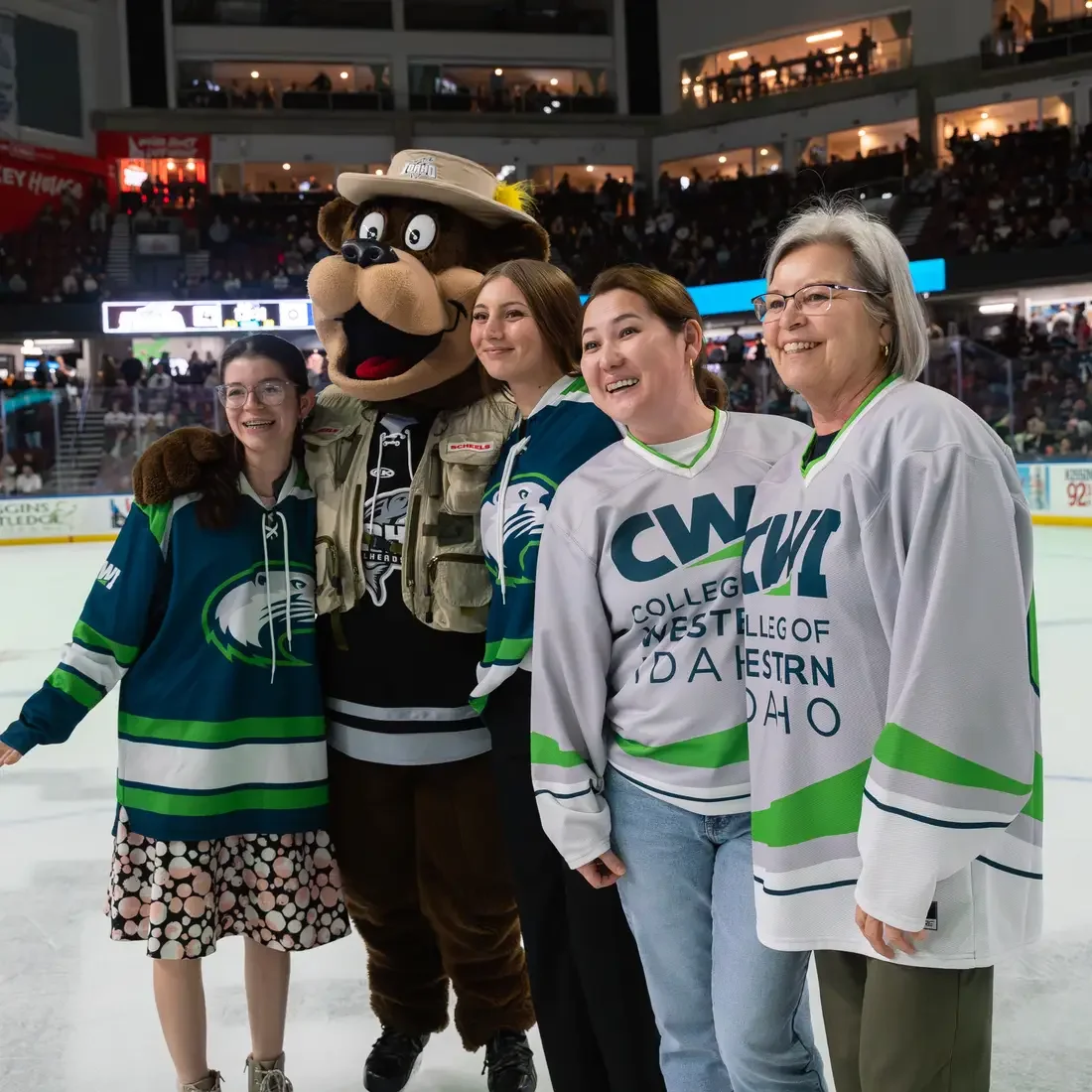 People and mascot stand on ice