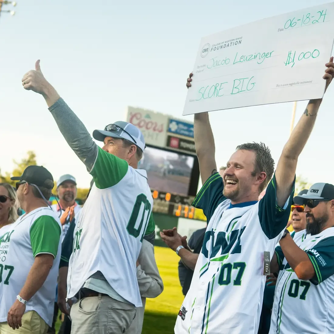 Student holding large check in front of crowd