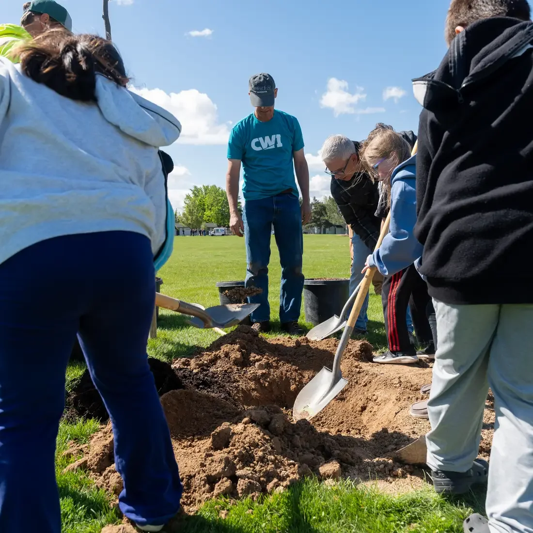 Adults and children dig hole