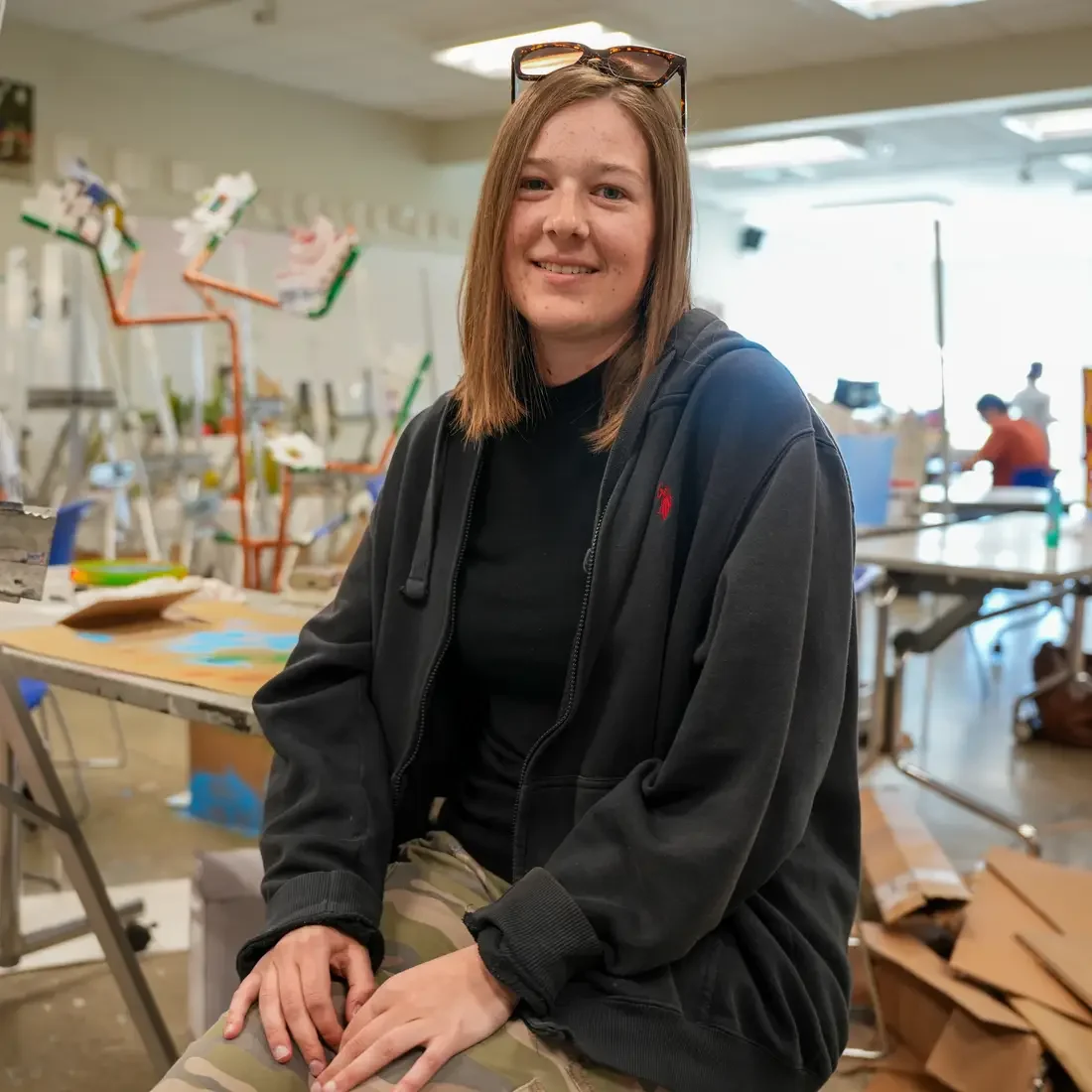 Bronwyn Hitchcock sitting on stool in art classroom