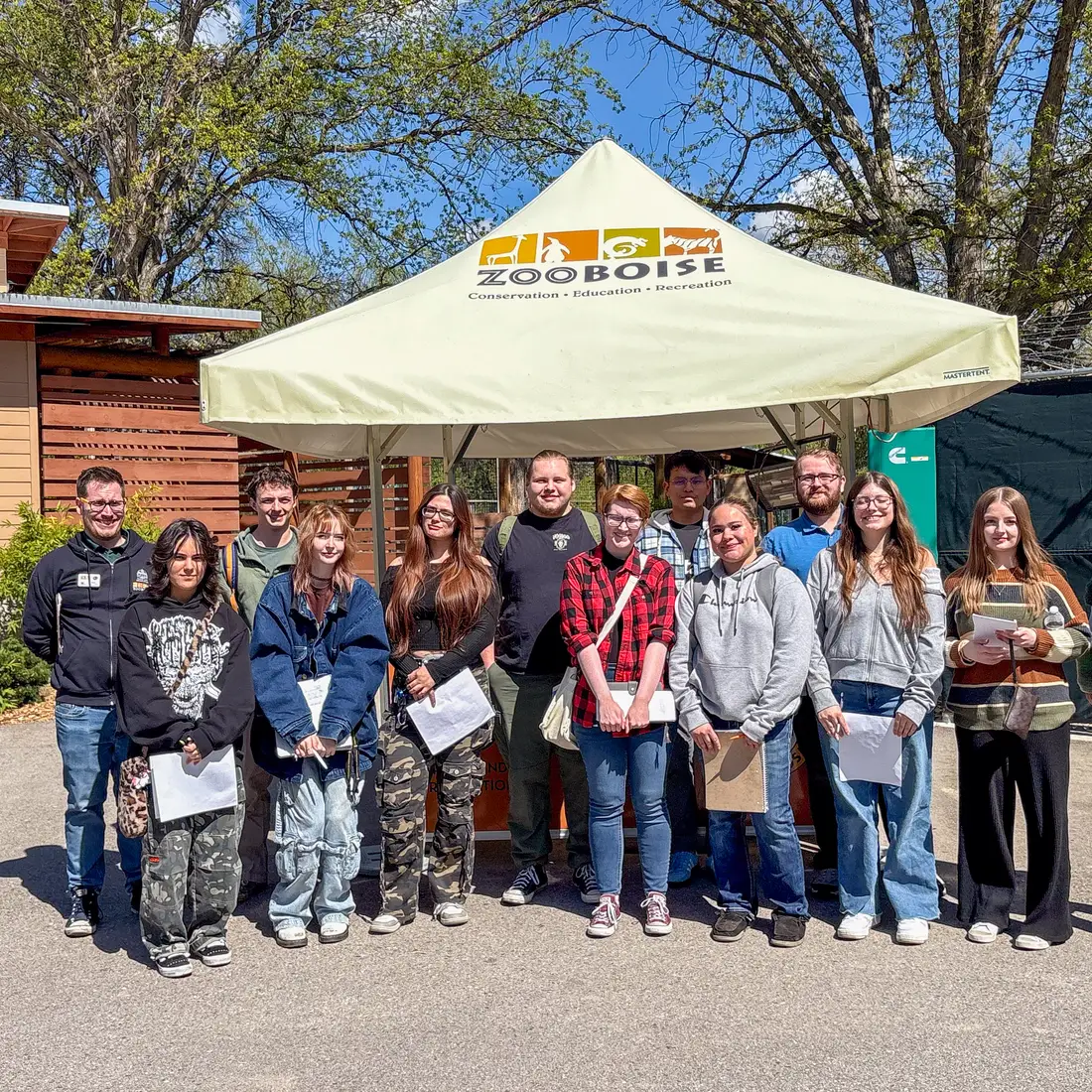 Class stands in front of a pop up tent