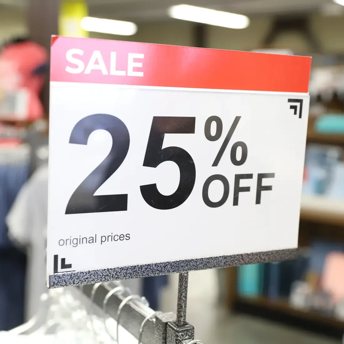 25 percent off sign on top of clothes