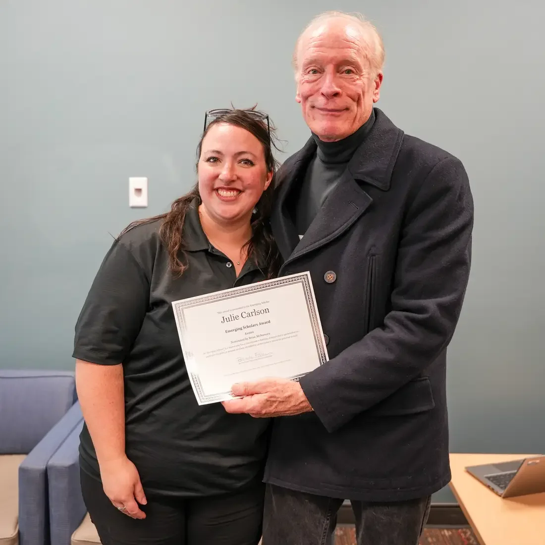 Faculty and student with a certificate