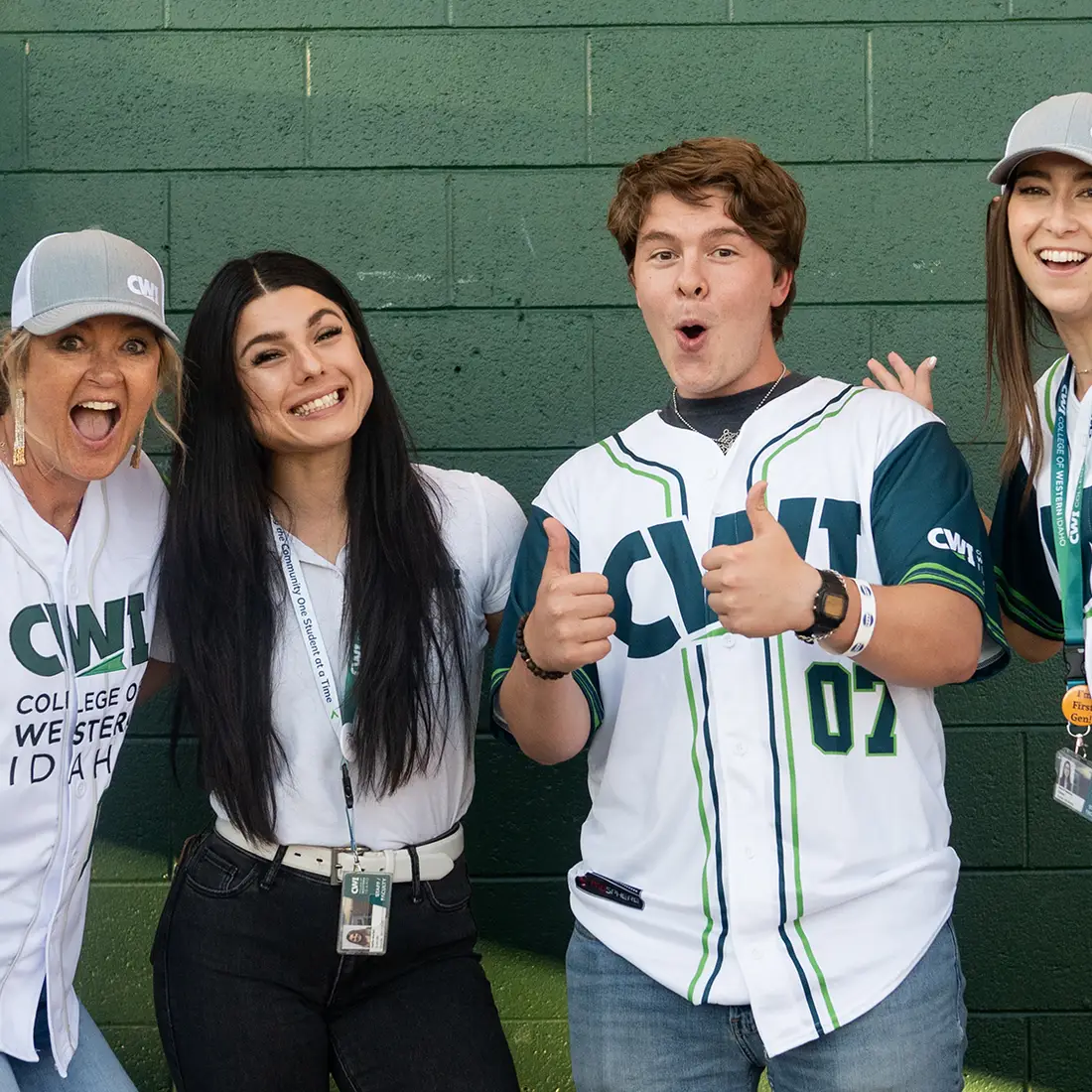 CWI employees and students posing excitedly for the camera with CWI sports jerseys on