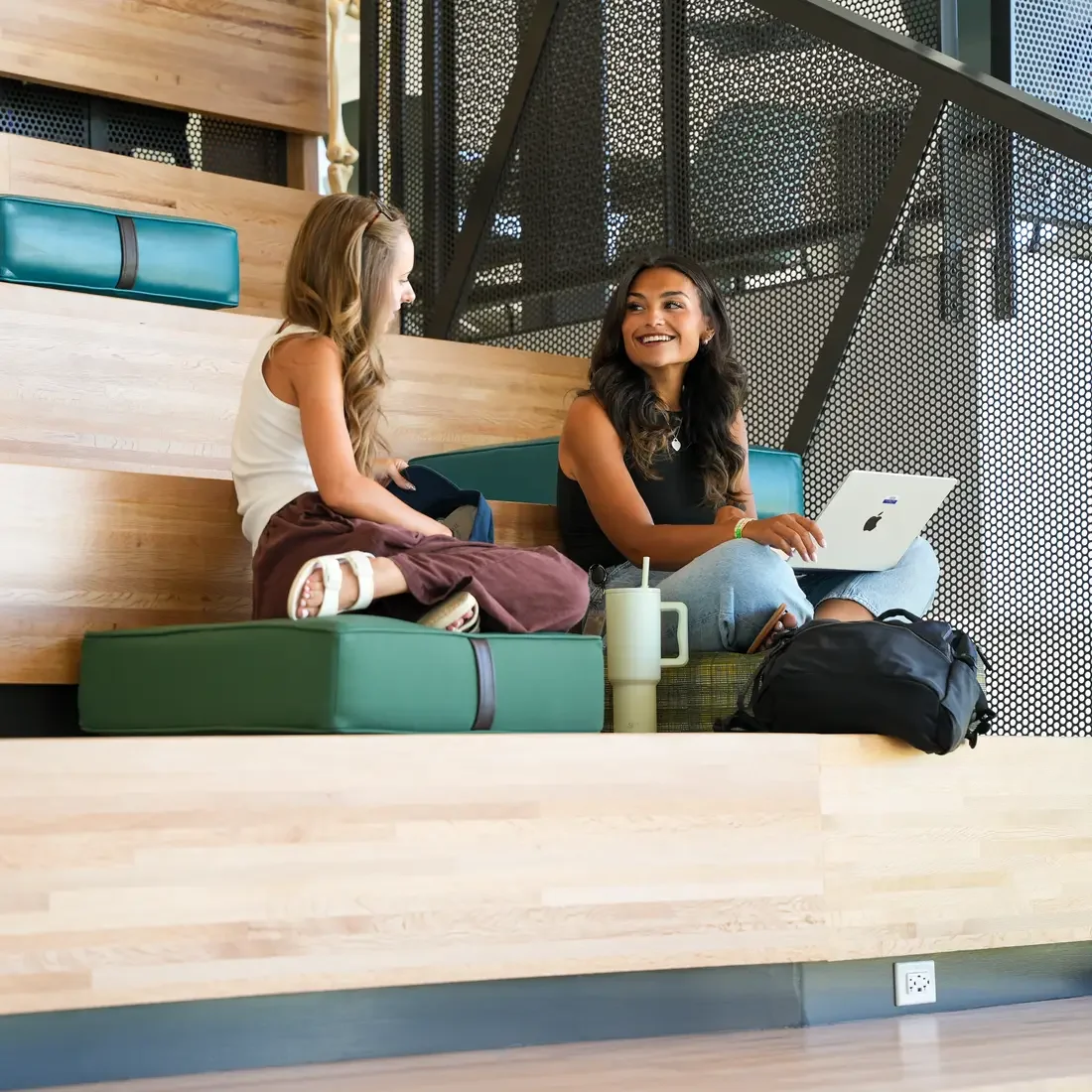 Two students sit on the Learning steps at the Student Success Center
