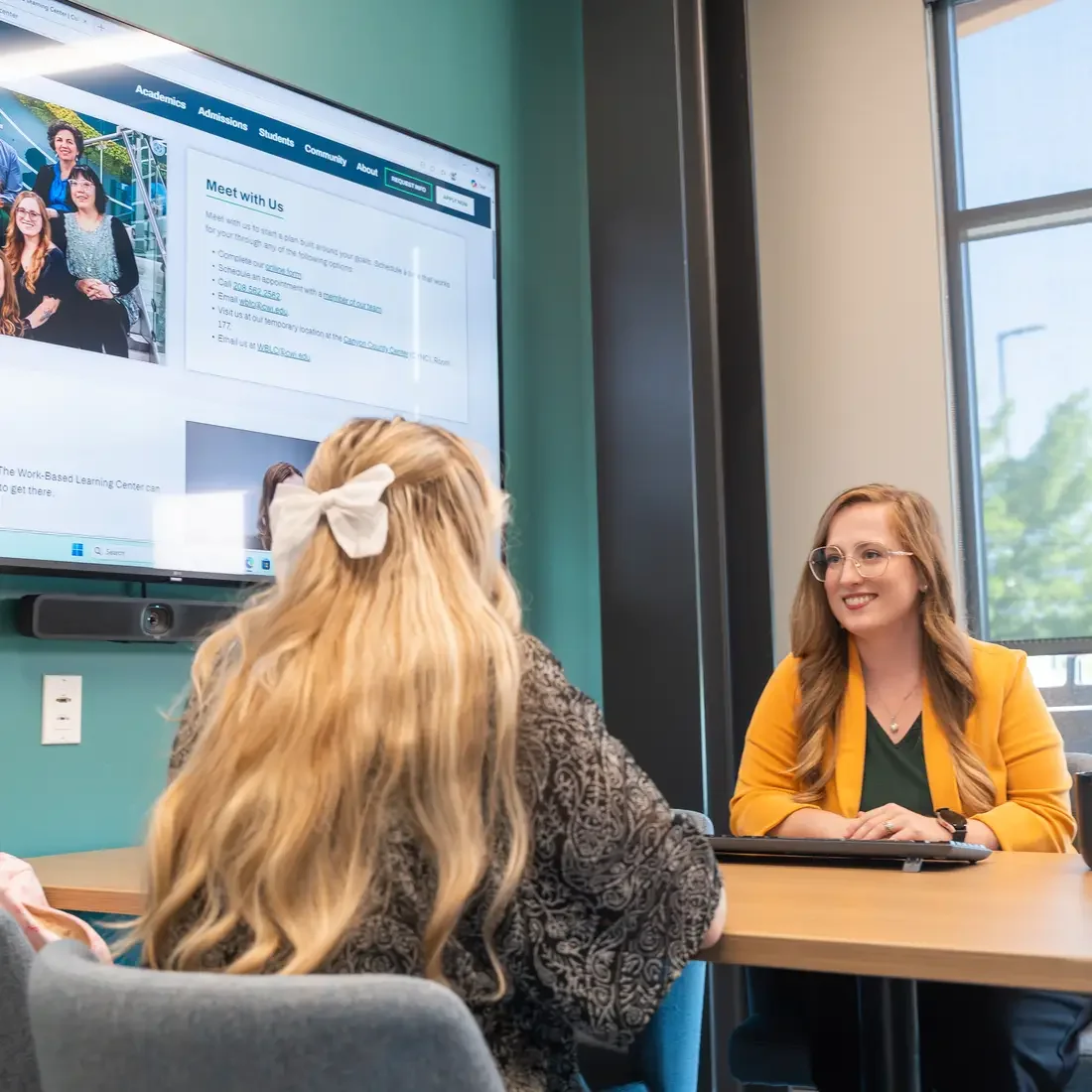 Work Based Learning Center employee chatting with student at table