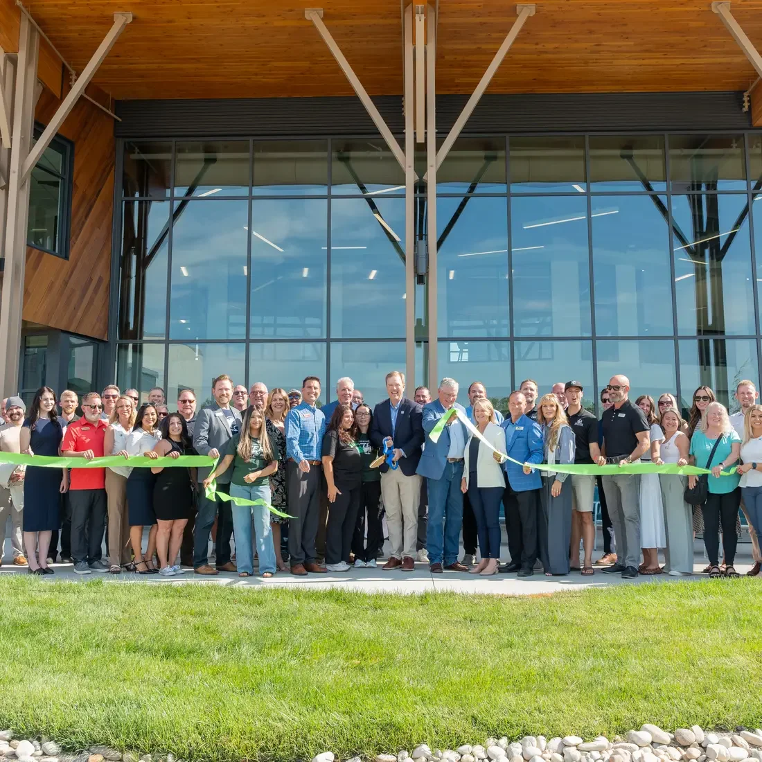 Group of people cut ribbon to new building
