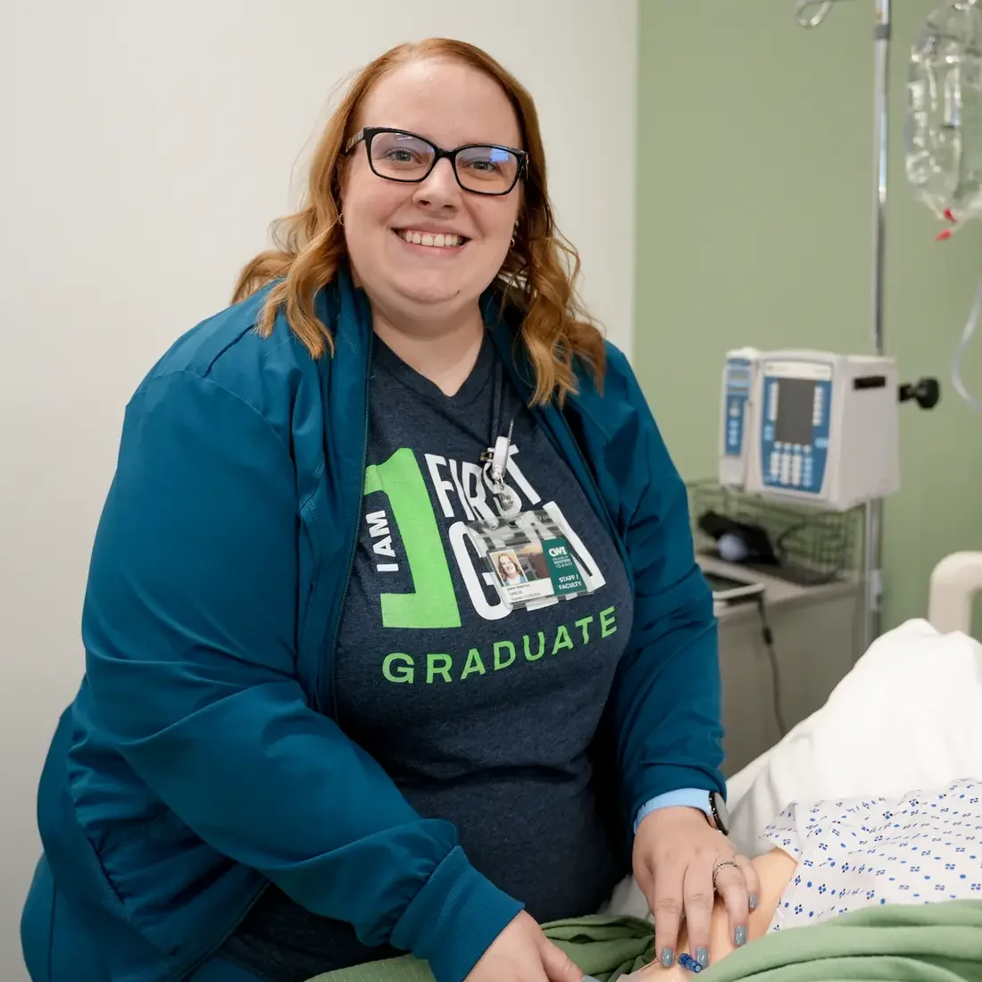 Faculty stands beside a simulation in a mannequin in bed