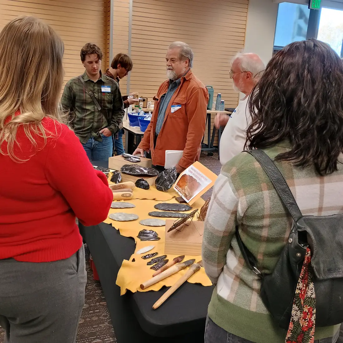 People gathered around table of items