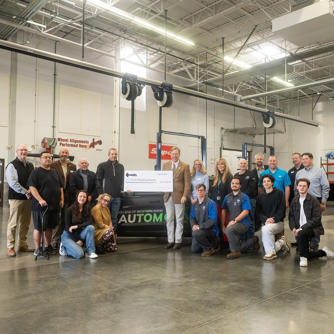 A group of students and college factory receive a ceremonial check of a $224,000 scholarship donation.