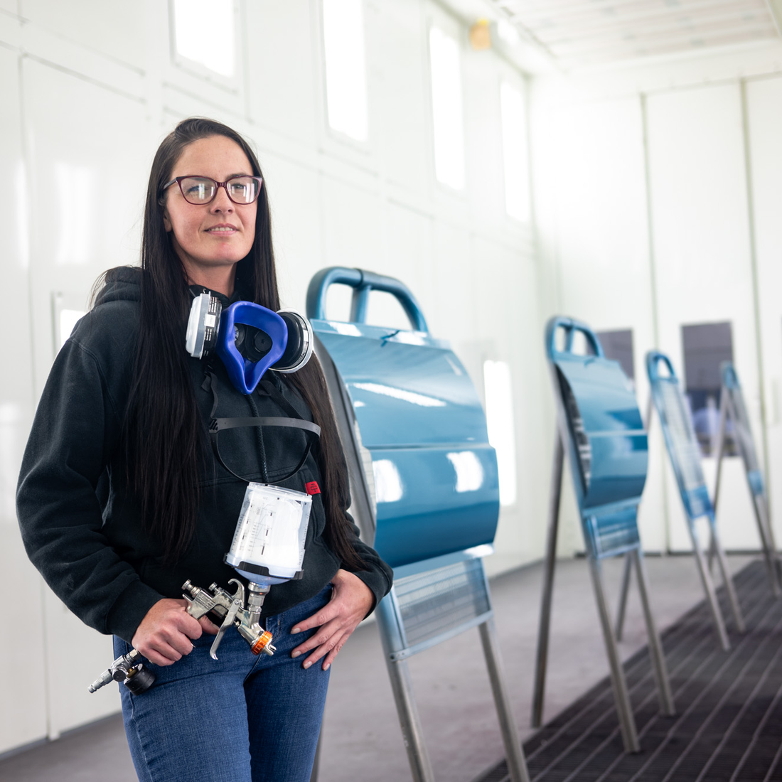 An automotive painting instructor poses for a portrait in a painting lab.