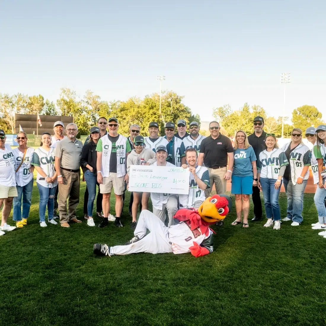 A group of people pose for a photo on a baseball field.