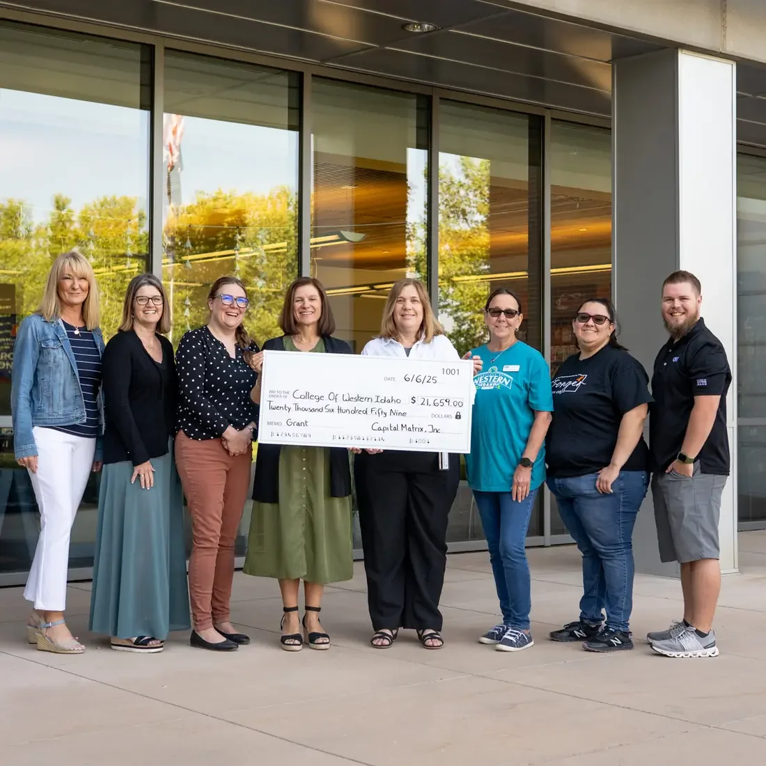 A ceremonial check is held by a group of people.