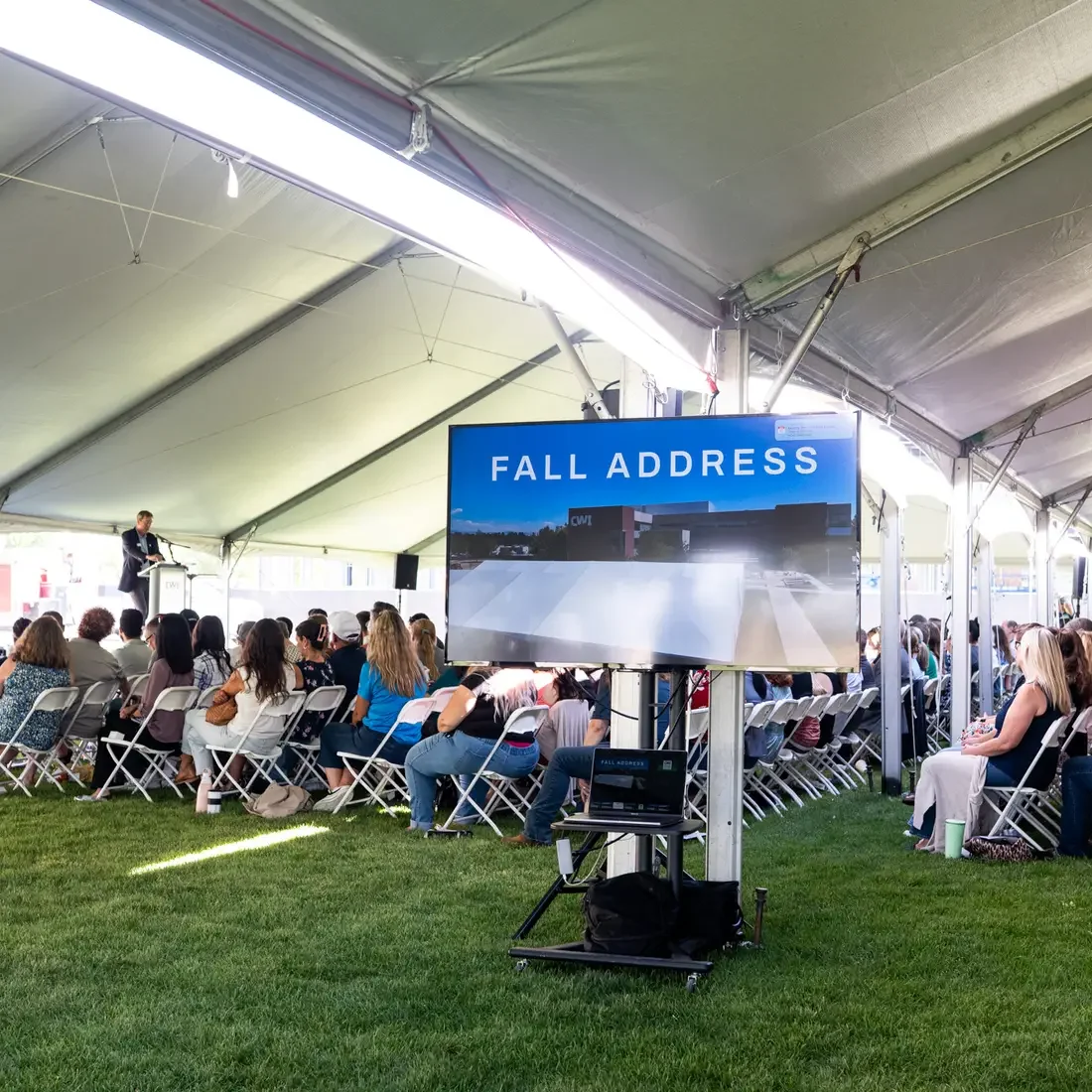 Faculty and staff sit and listen to a speaker addressing the room.