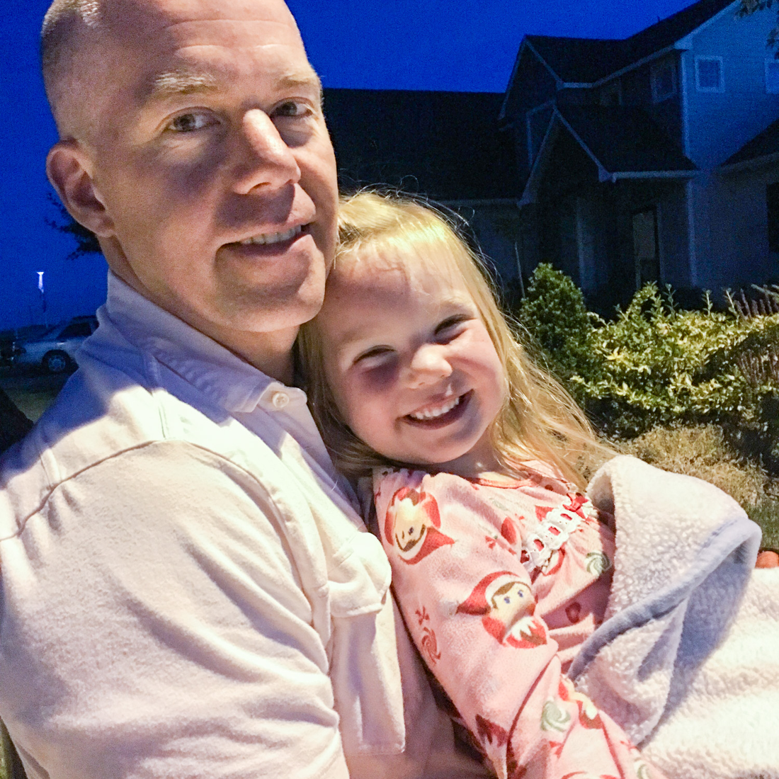 A photo of a man holding a smiling child.